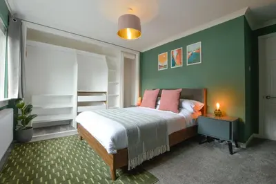 a bedroom with a bed and a green wall at Homely 2 Bed House with Private double driveway in Oban