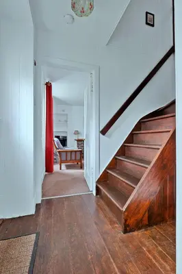 a staircase in a house with a red curtain at Finest Retreats - Lochead Cottage in Achahoish