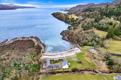 an aerial view of a house on a cliff next to the water at Finest Retreats - The Turbine House in Achahoish