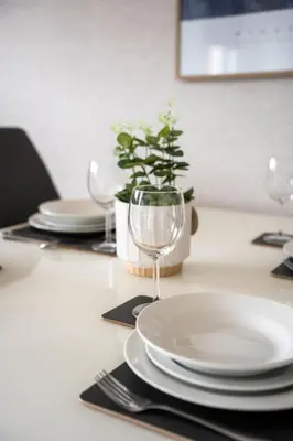 a table with plates and a wine glass on it at Stirling Street Stays in Tillicoultry