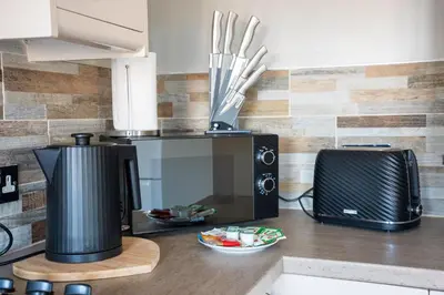 a kitchen counter with a microwave and a toaster at Carradale House in Falkirk