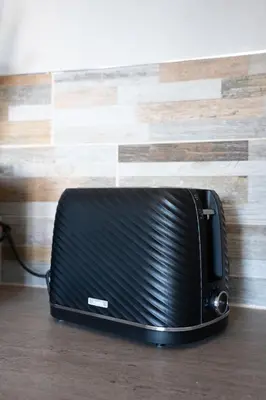 a black toaster oven sitting on a wooden floor at Carradale House in Falkirk