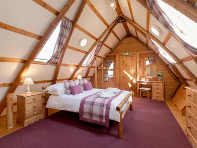 a bedroom with a bed and a desk in a attic at Villa Rabbie Burns Lodge by Interhome in Straiton