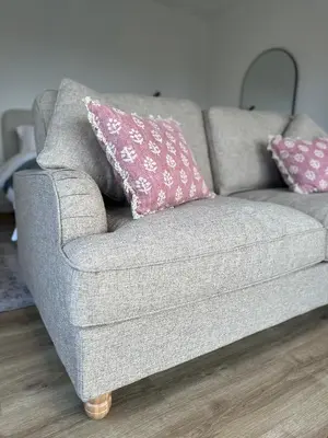 a gray couch with a pink pillow on it at The Byre, Summerhill Farm Stays in Balmaclellan