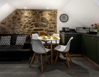 a living room with a table and chairs and a couch at Castle Street Apartments - Luxury Kilchattan Apartment in Rothesay