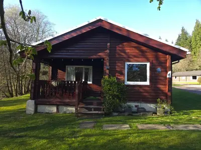 a log cabin with a porch and a window at Stravaigin Lodges in Rashfield
