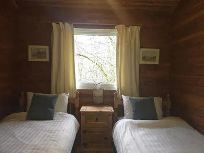 a bedroom with two beds and a window at Stravaigin Lodges in Rashfield