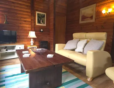 a living room with a couch and a table at Stravaigin Lodges in Rashfield