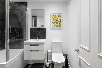 a white bathroom with a toilet and a sink at Castle Street Apartments - Luxury Scalpsie Apartment in Rothesay