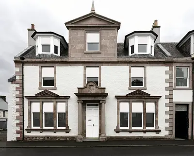 a large white brick house with white windows at Castle Street Apartments - Luxury Scalpsie Apartment in Rothesay