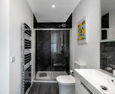 a white bathroom with a shower and a toilet at Castle Street Apartments - Luxury Scalpsie Apartment in Rothesay