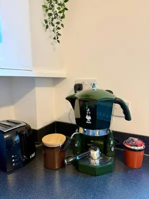 a green coffee maker sitting on a counter next to a toaster at 2 Bedroom Apartment near Glasgow City Centre, Celtic Park and Emirates Arena in Glasgow