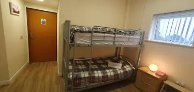 a bunk bed in a small room with a window at Edenmill Farm in Glasgow