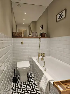 a white bathroom with a tub and a toilet at Comely Bank Coorie in Edinburgh