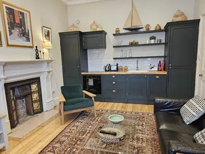 a living room with a couch and a kitchen at Comely Bank Coorie in Edinburgh
