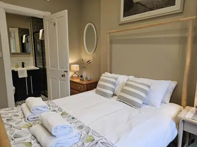 a bedroom with a white bed with towels on it at Comely Bank Coorie in Edinburgh
