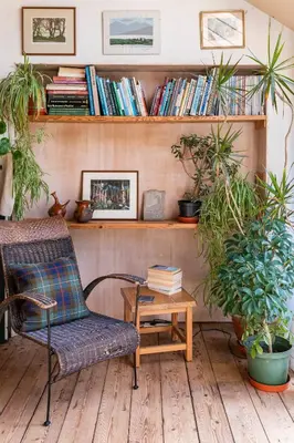a room with a chair and a book shelf with books at B&B on Beautiful Organic Homestead, Edinburgh in Loanhead