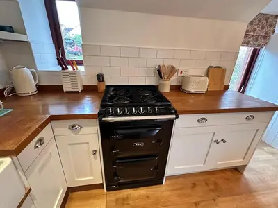 a kitchen with a black stove and white cabinets at Drymen View in Drymen