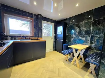 a kitchen with a table and a sink and a counter at Super luxury 2 bedroom, full house sleep 5 with garden & parking close to airport in Elderslie