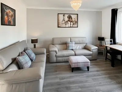 a living room with a couch and a table at Cambusmoon Apartment in Gartocharn