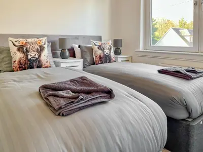 a bedroom with two beds with towels on them at Cambusmoon Apartment in Gartocharn