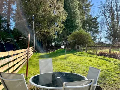 a table and chairs in a yard with a fence at Cambusmoon Apartment in Gartocharn