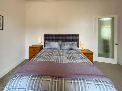 a bedroom with a large bed with two night stands at Glenfyne Apartment - Uk49318 in Ardrishaig