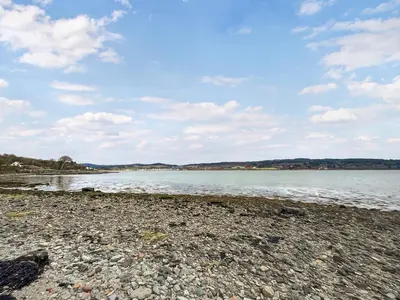 a rocky beach with the water and clouds in the sky at Glenfyne Apartment - Uk49318 in Ardrishaig