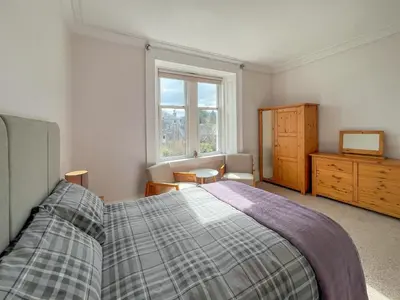 a bedroom with a bed and a dresser and a window at Glenfyne Apartment - Uk49318 in Ardrishaig