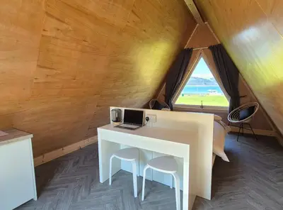 a desk with a laptop on it in a room with a window at The Hideouts at Port nan Gael Campsite in Pennyghael