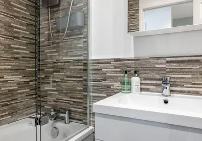 a bathroom with a sink and a shower at Cairn BNB Introduces Mavisbank Gardens - where homely charm meets modern living in Glasgow
