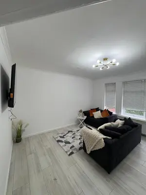 a living room with a black couch and a television at Cozy 3 Bed Home, Free Parking 8 min to City Centre in Cowlairs
