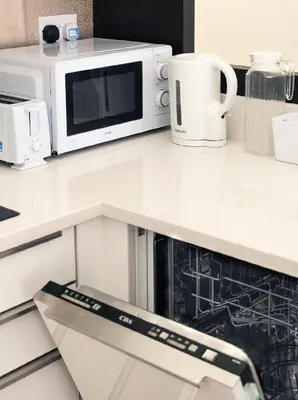 a white kitchen counter with a microwave and appliances at b&b in Edinburgh in Edinburgh
