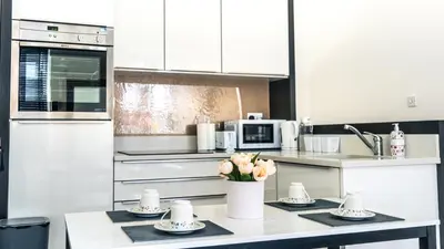 a kitchen with white cabinets and a table with flowers on it at b&b in Edinburgh in Edinburgh