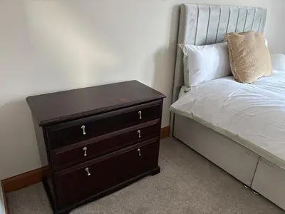 a bedroom with a bed and a dresser next to it at Crescent Corner 44 Seamore Street 3 Bedroom in Largs