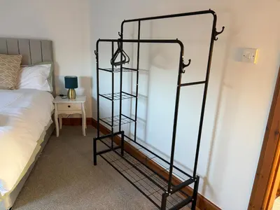 a black book shelf next to a bed in a room at Crescent Corner 44 Seamore Street 3 Bedroom in Largs