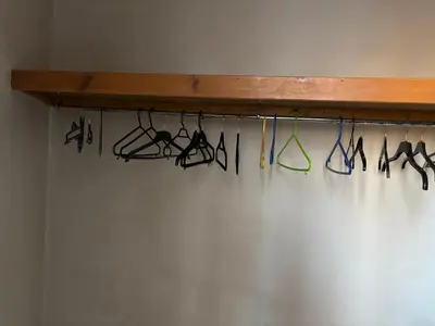 a rack of hangers with umbrellas on a wall at Crescent Corner 44 Seamore Street 3 Bedroom in Largs