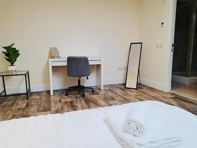 a bedroom with a desk and a chair and a mirror at Clyde Cottage in Lamington