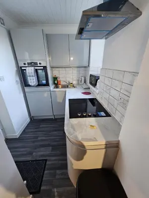 a small kitchen with a sink and a counter top at Addex Apartment in Dunfermline