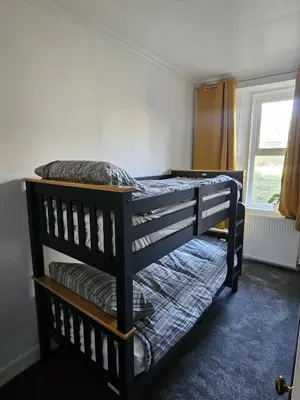 two bunk beds in a room with a window at Addex Apartment in Dunfermline