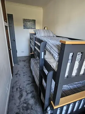 a bedroom with a black bunk bed in a room at Addex Apartment in Dunfermline