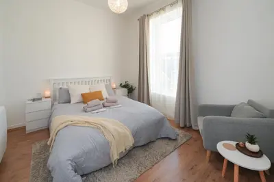 a white bedroom with a bed and a couch at Central 1-bed flat - Walk to shops, pubs and station in Saltcoats