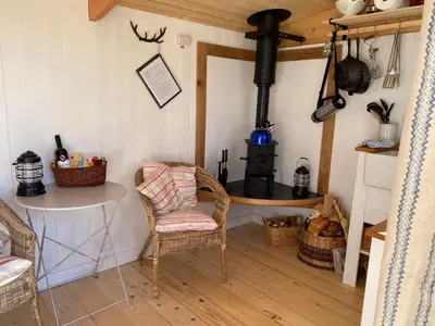 a room with a chair and a stove in a room at The Hidden Shepherds Hut- Off Grid Retreat in Castle Douglas