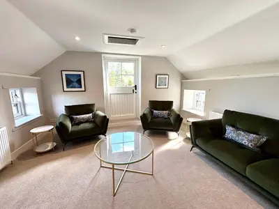 a living room with two couches and a glass table at The Bothy, Callander in Callander