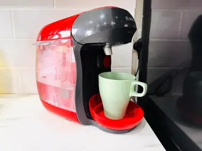 a coffee maker with a cup on a red stand at Luxury Grangemouth accomodation with free parking in Falkirk