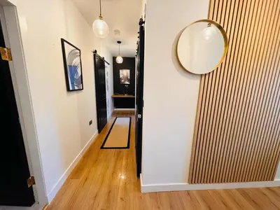 a hallway with a door and a mirror on the wall at Luxury Grangemouth accomodation with free parking in Falkirk