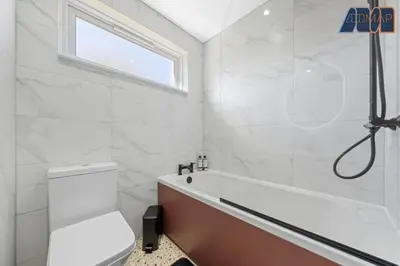 a white bathroom with a tub and a toilet at 2 Bed Sleeps 4 in Dunfermline in Cairneyhill