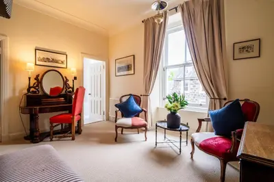 a room with chairs and a piano and a table at The Royal Hotel in Comrie