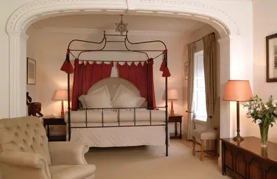 a bedroom with a canopy bed with a red curtain at The Royal Hotel in Comrie