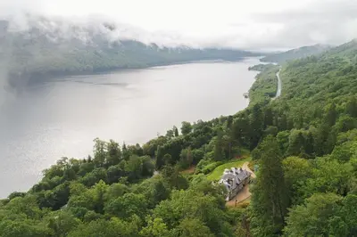 a view of a lake and a house on a hill at Sequoia House in Tarbet